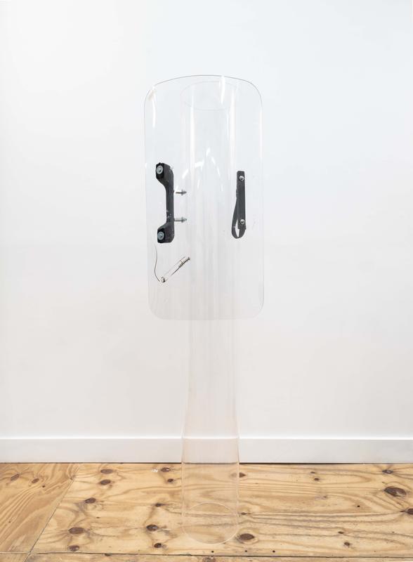 Louis Osmosis ,  Smokin' Tiki , 2024. Riot shield, acrylic tube, dry-erase marker, hardware. 72 x 19 x 11 inches.