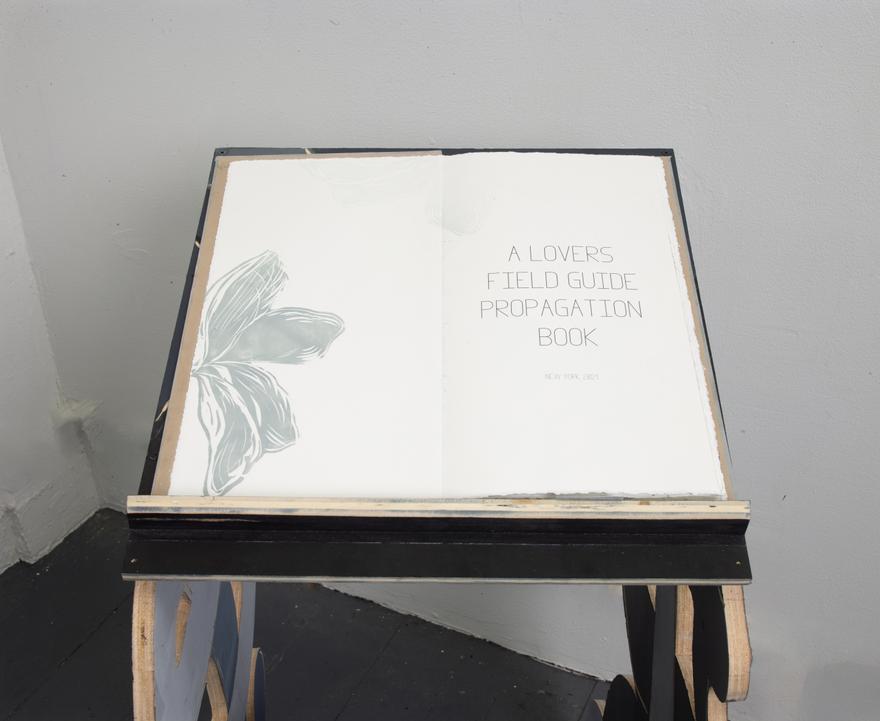 Luján Pérez ,   Lovers Field Guide propagation Book , 2021. Hand printed hand bound book that sits on a handmade sculpture book stand comprised of handmade oil and water based inks, plexi glass, birch plywood, fishing wire, screws, magic sculpt, xerox transfers, trace monotype on arches paper. 21 x 21 x 48 inches.