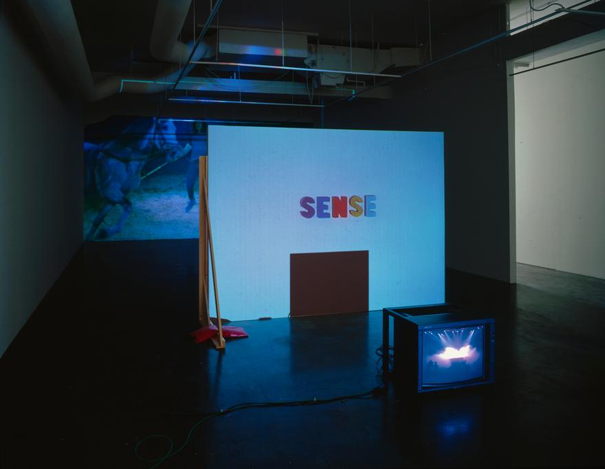 The best sense is the nonsense , 1998 Two (2) video projectors, one (1) video monitor, three (3) media players, free standing wall and existing architecture Installation view, York University Art Gallery, Toronto, Canada