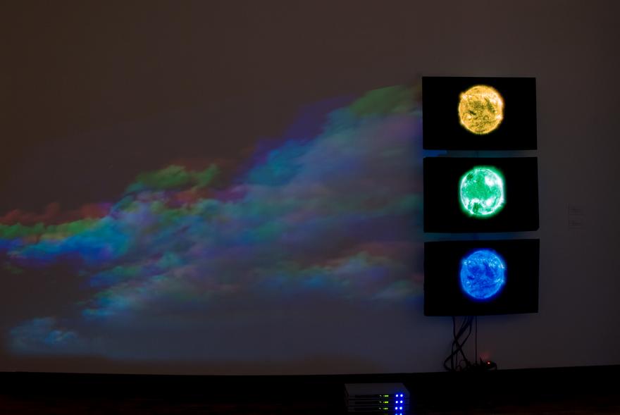 Oculus , 2001 One (1) video projector, one (1) media player, one (1) round mirror, Lee filters and existing architecture Blue, Green, Yellow Suns, 2000 Three (3) video monitors, three (3) media players Installation view, Multiverse, Claremont Museum of Art, Claremont, CA, 2008  